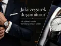 Elegancki mężczyzna w granatowym garniturze i białej koszuli, z klasycznym zegarkiem na nadgarstku. Dowiedz się, jak nosić zegarek do koszuli.