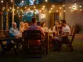 Rodzina i przyjaciele na garden party, gra na gitarze, rozmowy. Jak się ubrać? Luźne, letnie stroje idealne na wieczorne spotkanie w ogrodzie.