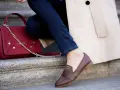 Elegancka stylizacja z czerwoną torebką i brązowymi mokasynami. Idealna na spacer po stolicy mody.