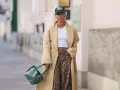 Modna kobieta w beżowym płaszczu i spodniach w panterkę. Stylowe spodnie w panterkę to klucz do odważnych stylizacji.