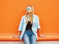 Dziewczyna w okularach i jeansach, z luźną koszulą jeansową z czym łączyć – idealny casualowy look na co dzień.