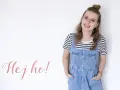 Uśmiechnięta dziewczyna w stylu normcore, w jeansowej sukience na szelkach i pasiastym t-shircie, z napisem "Hej ho!".