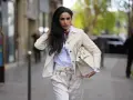 Eleganckie stylizacje z białymi spodniami: kobieta w kremowym żakiecie, białej koszuli i spodniach, z torebką Birkin.
