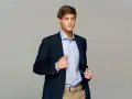 Elegancki mężczyzna w granatowej marynarce i błękitnej koszuli. Idealny przykład, jak się ubrać na imprezę firmową mężczyzna, by wyglądać stylowo i profesjonalnie.
