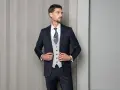 Mężczyzna w granatowym garniturze, jasnej kamizelce i wzorzystym krawacie. Elegancki wybór: krawat czy mucha?