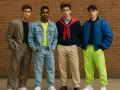 Czterech młodych mężczyzn prezentuje odważne stylizacje, zapowiadając trendy w **modzie męskiej 2026**.