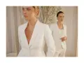 Dwie kobiety w białych garniturach, uosobienie power dressingu. Eleganckie, pewne siebie, gotowe na podbój świata.
