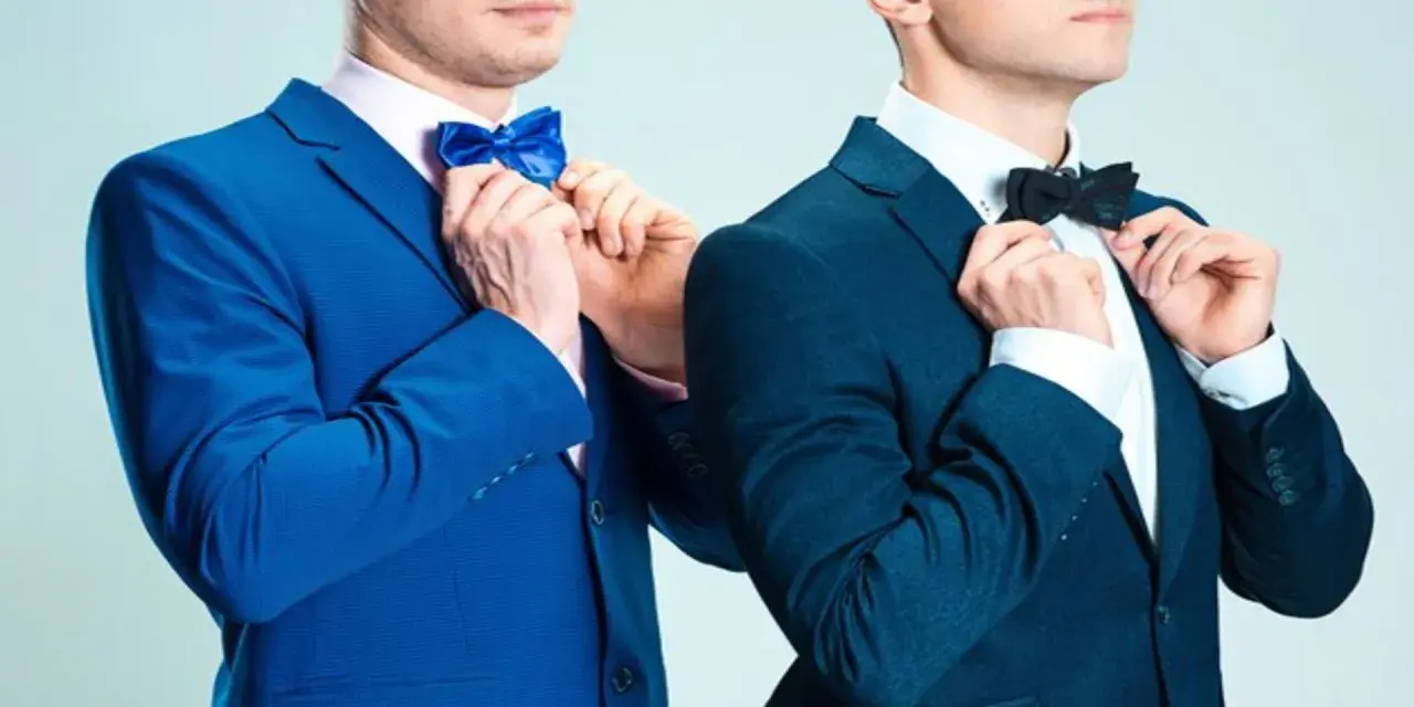 Dwóch mężczyzn w granatowych garniturach poprawia muszki. Jeden w niebieskiej, drugi w czarnej. Jaka mucha do granatowego garnituru?