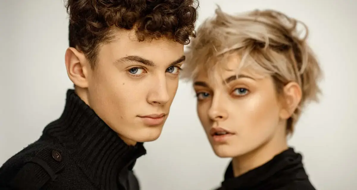 Młoda para, on z kręconymi włosami, ona z blond pixie cut, w czarnych golfach. Ich spojrzenia sugerują, że tworzą idealny **matching** duet.