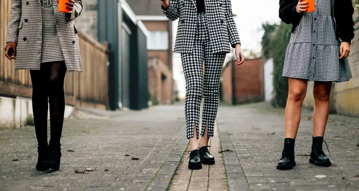 Trzy kobiety w kratę. Jakie buty do spodni w kratę męskie? Eleganckie oksfordki, botki lub sznurowane trapery.