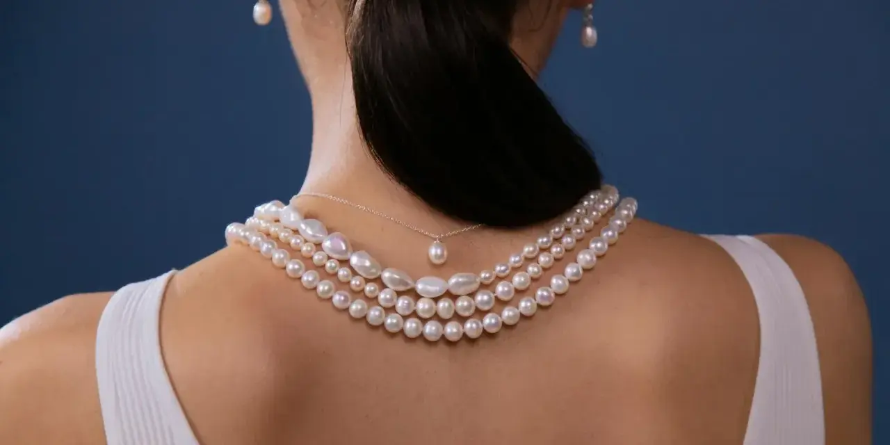 Elegancki naszyjnik z pereł, idealny do różnorodnych stylizacji. Delikatne perły zdobią dekolt, dodając klasy.