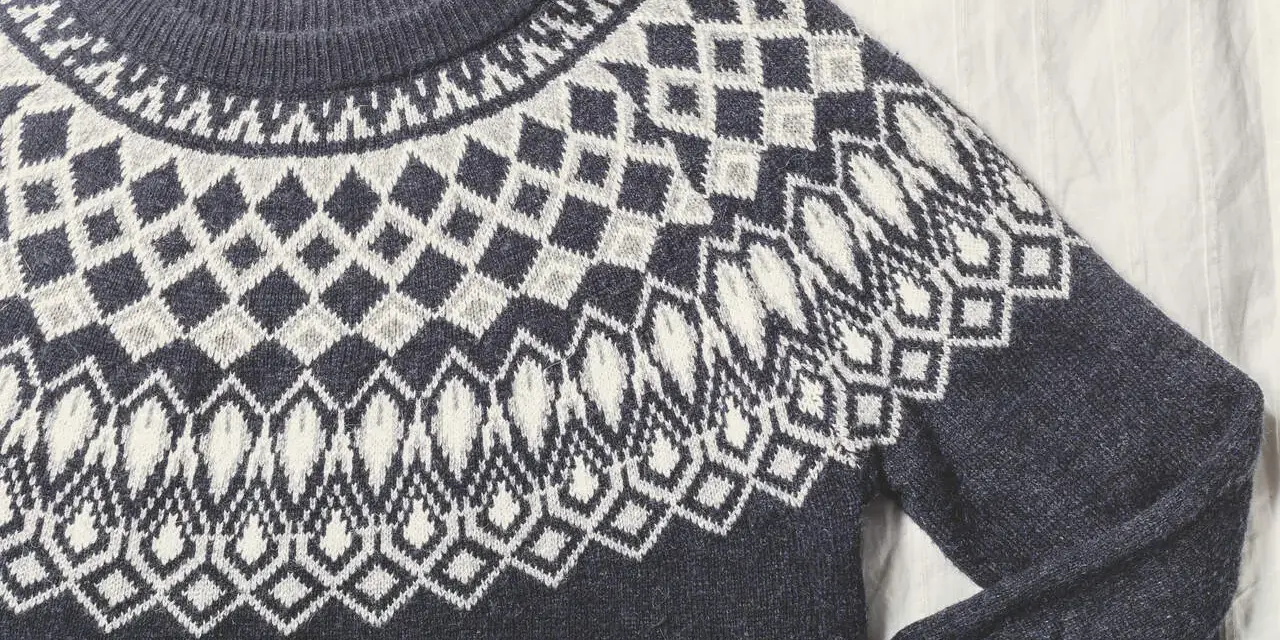 Sfilcowany sweter z granatowo-białym wzorem norweskim. Idealny na zimowe wieczory.