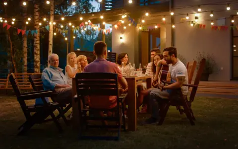 Rodzina i przyjaciele na garden party, gra na gitarze, rozmowy. Jak się ubrać? Luźne, letnie stroje idealne na wieczorne spotkanie w ogrodzie.