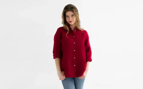 Kobieta w bordowej koszuli męskiej i jeansach. Stylowa, luźna koszula to świetna baza do wielu stylizacji.