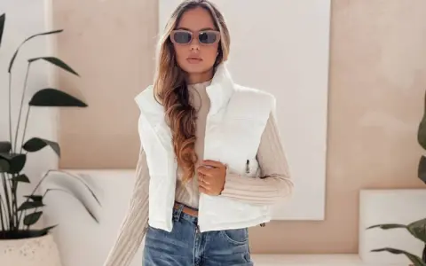 Modna kobieta w białej kamizelce i okularach przeciwsłonecznych prezentuje stylowe stylizacje z kamizelką.