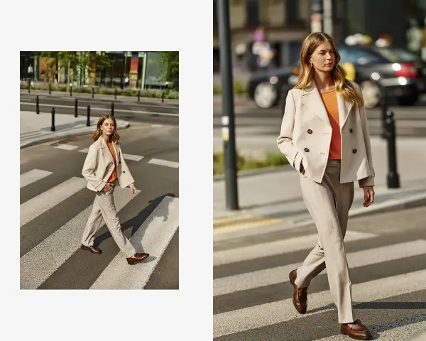 Elegancka stylizacja: jaka marynarka do beżowych spodni? Modelka w beżowej marynarce dwurzędowej i spodniach w prążek na pasach.