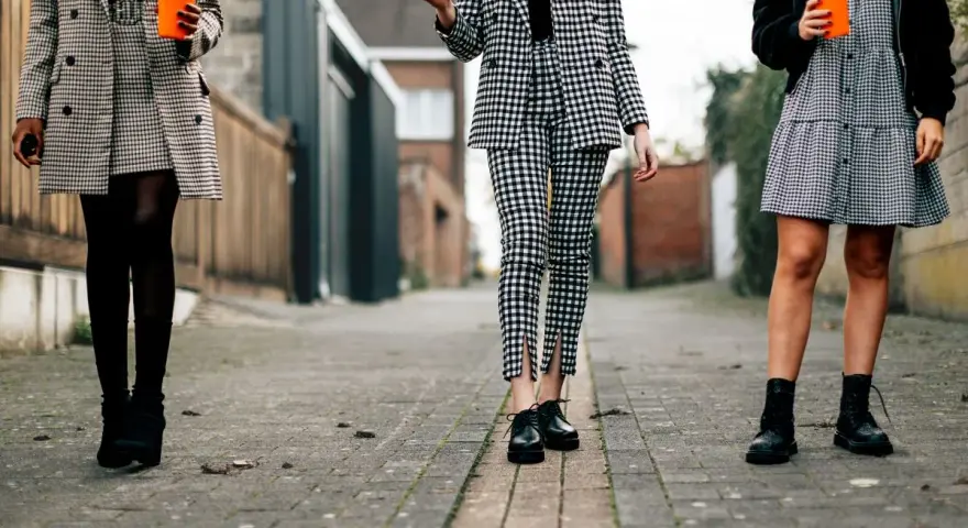 Trzy kobiety w kratę. Jakie buty do spodni w kratę męskie? Eleganckie oksfordki, botki lub sznurowane trapery.