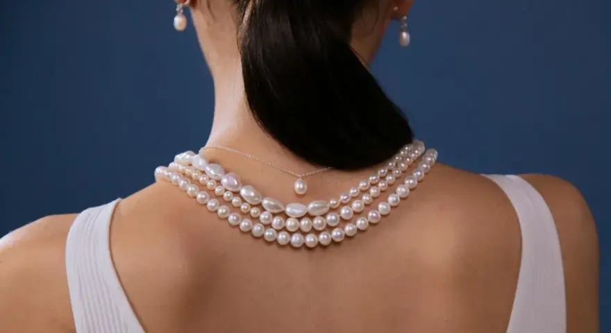 Elegancki naszyjnik z pereł, idealny do różnorodnych stylizacji. Delikatne perły zdobią dekolt, dodając klasy.