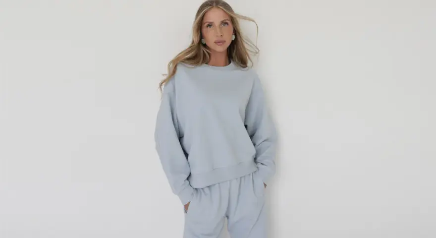 Kobieta w błękitnym, luźnym komplecie dresowym. Eleganckie dresy stylizacje, które łączą komfort z modnym wyglądem.