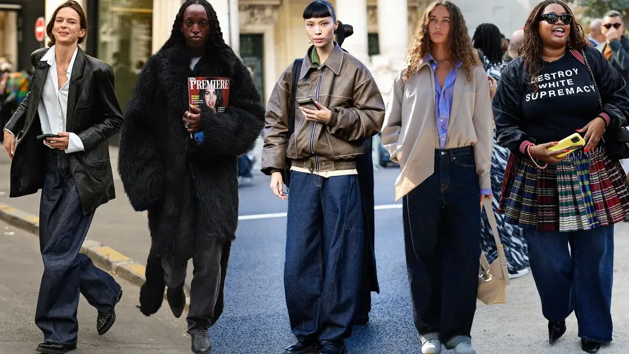 Pięć osób prezentuje modę uliczną w stylu baggy. Od lewej: kobieta w skórzanej kurtce i szerokich jeansach, osoba w czarnym futrze i jeansach, kobieta w brązowej kurtce bomber i jeansach, kolejna w beżowej marynarce i jeansach, a na końcu kobieta w blu...