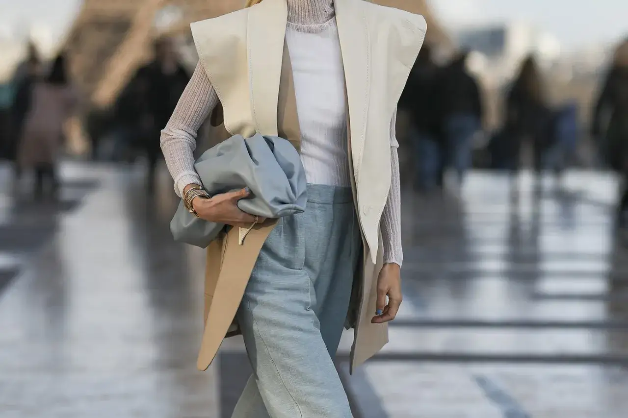 Eleganckie stylizacje z kamizelką: beżowa kamizelka, błękitna torebka i jasne spodnie tworzą szykowny look.